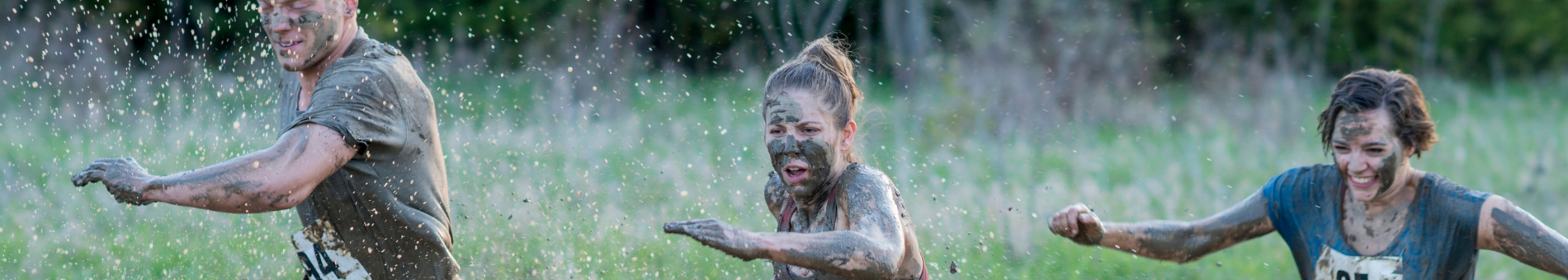 3 mensen die deelnemen aan een mudrun