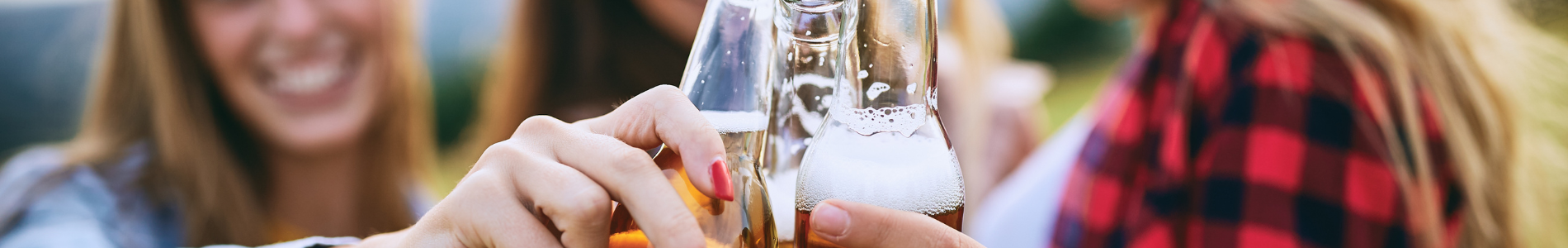 drie dames die proosten met bierflesjes